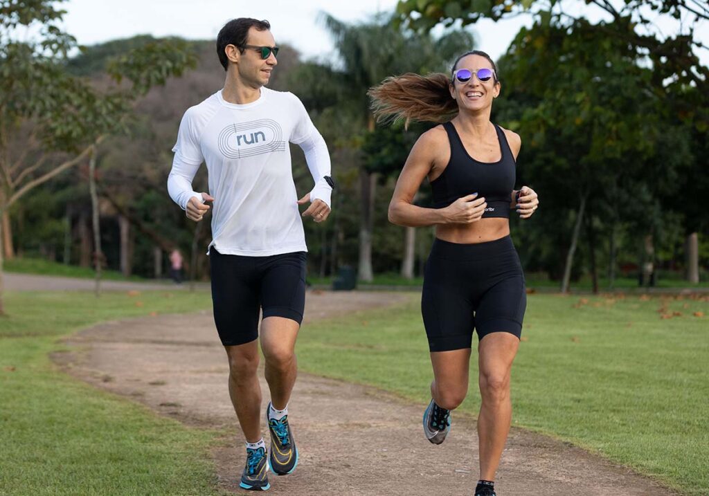 Casal correndo em um parque no domingo de manhã